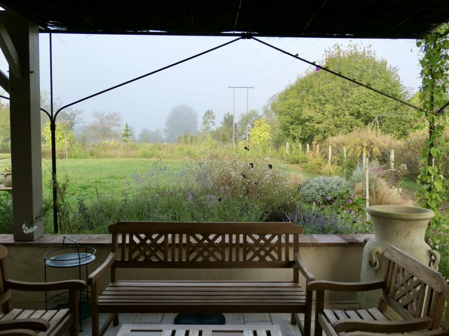 Des massifs fleuris accompagnent la terrasse et invitent vers le jardin